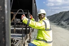 rail worker climing onto cargo train